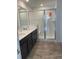 Bathroom featuring dual sinks, a glass-enclosed shower, and modern fixtures at 6750 Juniper Dr, Thornton, CO 80602