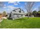 Expansive backyard with a covered patio, lush green lawn, and mature trees at 529 Olympia Ave, Longmont, CO 80504