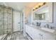 Bright bathroom with double vanity, marble countertops, and a stylish tiled shower at 529 Olympia Ave, Longmont, CO 80504
