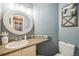 Neat half-bathroom with charming decor, an oval mirror, and modern fixtures at 529 Olympia Ave, Longmont, CO 80504