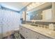 Stylish bathroom with double sink vanity, marble countertops, decorative fixtures, and a shower with curtain at 529 Olympia Ave, Longmont, CO 80504