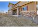 Home exterior with stone accents, manicured lawn, and charming architectural details at 11602 Pine Canyon Dr, Parker, CO 80138