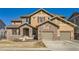 Charming two-story home featuring a stone facade, two-car garage, and well-kept lawn at 11602 Pine Canyon Dr, Parker, CO 80138