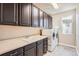 Well-equipped laundry room featuring sink, counter space, dark cabinetry, and modern washer/dryer at 11602 Pine Canyon Dr, Parker, CO 80138