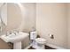 Clean powder room with pedestal sink, oval mirror, and wood-look flooring at 11602 Pine Canyon Dr, Parker, CO 80138