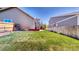 Spacious backyard with green grass, garden beds, and a privacy fence at 2980 E 135Th Dr, Thornton, CO 80241