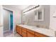 Bathroom featuring a dual sink vanity with granite countertops, and decorative mirrors and lighting at 2980 E 135Th Dr, Thornton, CO 80241