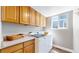 Laundry room with wood cabinets, counter space, and a modern washing machine at 2980 E 135Th Dr, Thornton, CO 80241