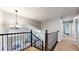Open staircase with iron railing leading to an upper level with carpeted hallway at 2980 E 135Th Dr, Thornton, CO 80241