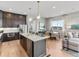 Spacious open-concept kitchen with a large center island, modern appliances, and stylish pendant lighting at 6244 N Lisbon St, Aurora, CO 80019