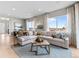 Bright living room featuring a large sectional sofa, contemporary decor, and an abundance of natural light at 6244 N Lisbon St, Aurora, CO 80019