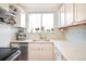 Bright kitchen features white cabinetry, stainless steel appliances, and natural light at 1232 Wabash St, Denver, CO 80220
