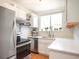 Charming kitchen with stainless steel appliances, white cabinets, and a window above the sink at 1232 Wabash St, Denver, CO 80220