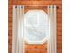 Close-up of a unique, octagonal window with white frame and sheer curtains at 1232 Wabash St, Denver, CO 80220