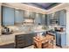 Well-lit kitchen boasts granite countertops, stainless steel appliances, and stylish blue cabinetry at 300 S Lincoln St, Denver, CO 80209