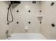 Bathtub and shower area featuring chrome fixtures, white shelving, and decorative accents at 1390 N Emerson St # 101, Denver, CO 80218