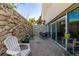 Outdoor patio showcasing stone walls, a metal table set, and access via glass sliding doors at 1390 N Emerson St # 101, Denver, CO 80218