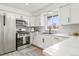 Well-appointed kitchen features white cabinetry, stainless steel appliances, and a functional layout with a large window at 3313 Jasmine St, Denver, CO 80207