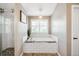 Bright bathroom with soaking tub, glass-enclosed shower, subway tile surround, and modern fixtures at 16658 Black Oak Ct, Parker, CO 80134