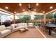 Relaxing covered patio with comfortable seating, dining table, ceiling fan, and backyard views with fence and trees at 16658 Black Oak Ct, Parker, CO 80134