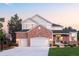 Beautiful two-story home featuring a brick facade, attached garages, a well-manicured lawn, and lovely curb appeal at 16658 Black Oak Ct, Parker, CO 80134