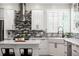 Spacious kitchen with white cabinets, stainless steel appliances, a mosaic tile backsplash, and a white farmhouse sink at 16658 Black Oak Ct, Parker, CO 80134