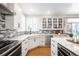 Open kitchen features white cabinetry, quartz countertops, stainless steel appliances, and a stylish backsplash at 16658 Black Oak Ct, Parker, CO 80134