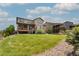 Backyard with a lush green lawn and a stone path leading towards a wooden fence and a large home at 578 Sage Grouse Cir, Castle Rock, CO 80109
