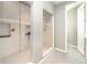 Bright bathroom featuring a glass shower, with light grey tiling, a shelf, and an open door at 578 Sage Grouse Cir, Castle Rock, CO 80109