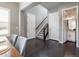Dining room with a gray wall, staircase, and entry to a half bath, accentuated by dark hardwood floors at 578 Sage Grouse Cir, Castle Rock, CO 80109