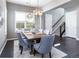 Dining room featuring a wooden table, gray chairs, modern light fixtures, dark floors, and plantation shutters at 578 Sage Grouse Cir, Castle Rock, CO 80109
