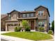 Charming two-story home with a well-manicured lawn and a covered front porch with stone accents at 578 Sage Grouse Cir, Castle Rock, CO 80109