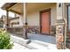 Inviting front porch with stone detailing on the columns and a bright front door entrance at 578 Sage Grouse Cir, Castle Rock, CO 80109
