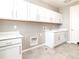 Bright laundry room with ample white cabinets, modern fixtures, and plenty of counter space at 578 Sage Grouse Cir, Castle Rock, CO 80109