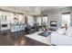 Open-concept living room with a stone fireplace, white sofa, and views of the modern kitchen at 578 Sage Grouse Cir, Castle Rock, CO 80109