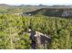 Aerial view of a stately home surrounded by lush forest and mountain views at 30082 Troutdale Ridge Rd, Evergreen, CO 80439