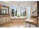 Bright bathroom featuring a soaking tub, dual vanities, and windows with scenic views at 30082 Troutdale Ridge Rd, Evergreen, CO 80439