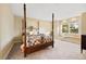 Spacious bedroom featuring a four poster bed and window bench with a scenic view at 30082 Troutdale Ridge Rd, Evergreen, CO 80439