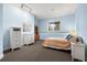 Well-lit bedroom with a queen bed, matching dressers, and a large window with outdoor views at 30082 Troutdale Ridge Rd, Evergreen, CO 80439