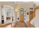 Bright foyer with an impressive front door, staircase, and an arched doorway leading into an office at 30082 Troutdale Ridge Rd, Evergreen, CO 80439