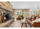 Cozy living room with a stone fireplace, hardwood floors, and a comfortable leather sofa at 30082 Troutdale Ridge Rd, Evergreen, CO 80439