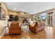 Inviting living room featuring a stone fireplace, built-in shelves, and hardwood floors at 30082 Troutdale Ridge Rd, Evergreen, CO 80439