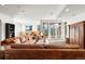 Spacious living room with a large leather sofa, carpeted floor, and glass doors to the outside at 30082 Troutdale Ridge Rd, Evergreen, CO 80439