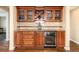 Charming bar area with custom cabinetry, glass display shelves, and a wine cooler at 5549 Lake Gulch Rd, Castle Rock, CO 80104