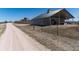 Exterior shot of an outbuilding near a dirt road and a house on a hill under a blue sky at 5549 Lake Gulch Rd, Castle Rock, CO 80104