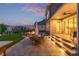 Outdoor patio area with beautiful landscaping, evening lighting, and a dining table with seating at 3256 Offbeaten Pl, Castle Rock, CO 80108