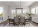 Bright dining room featuring a dark wood table with seating for six, plantation shutters, and elegant modern lighting at 3256 Offbeaten Pl, Castle Rock, CO 80108