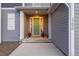 Welcoming front porch featuring a vibrant green door, stylish planters, and charming architectural details at 3256 Offbeaten Pl, Castle Rock, CO 80108