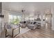Open-concept living room with a large sectional, modern furnishings, and seamless flow to the kitchen at 3256 Offbeaten Pl, Castle Rock, CO 80108