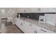 Mud room with white cabinets, granite counters, black backsplash, and bench seating at 3256 Offbeaten Pl, Castle Rock, CO 80108